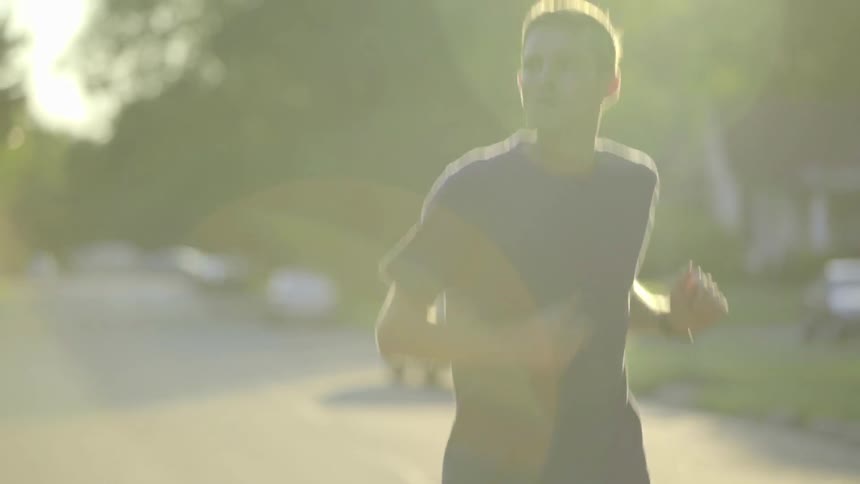 A man is jogging down the road
