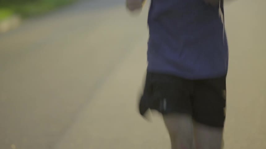A man is jogging down the road
