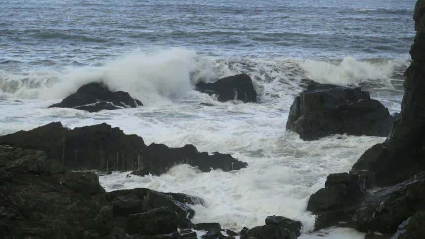 Waves crashing over and around rocks