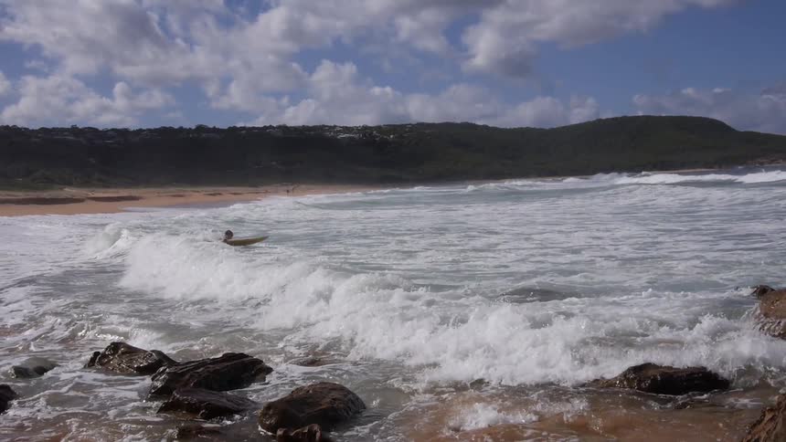 Surfer dives into the surf