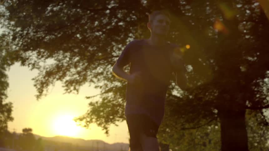 A man is jogging at sunset