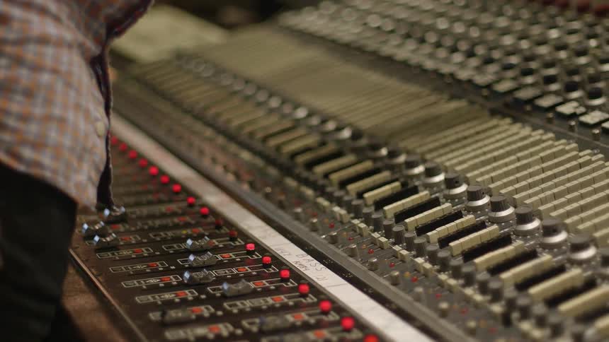 A man works at a large control panel