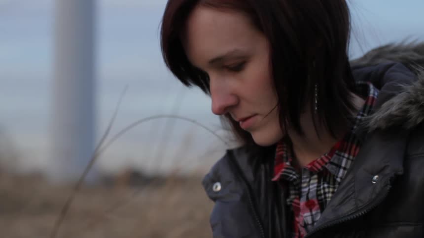 A woman is writing in a field