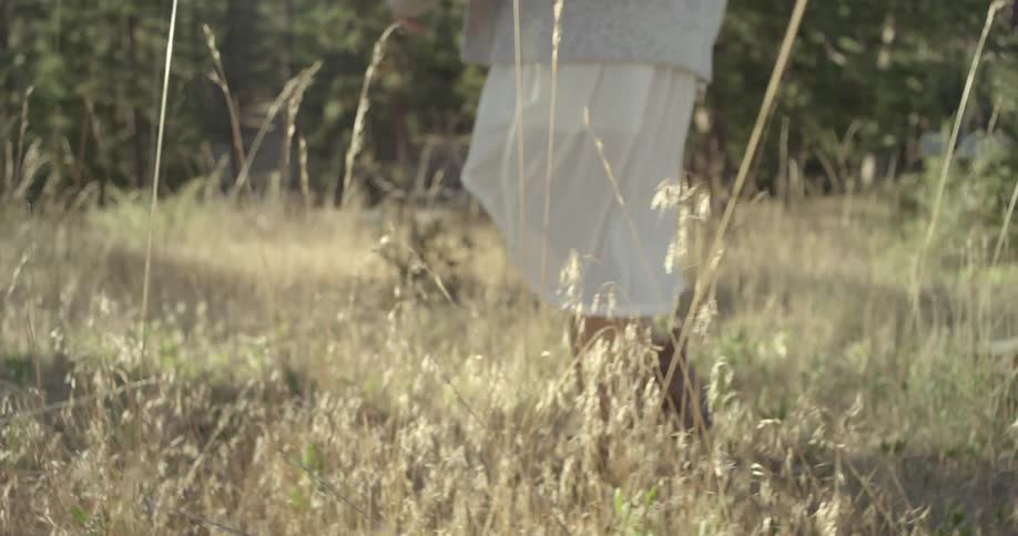 A woman is walking through a field