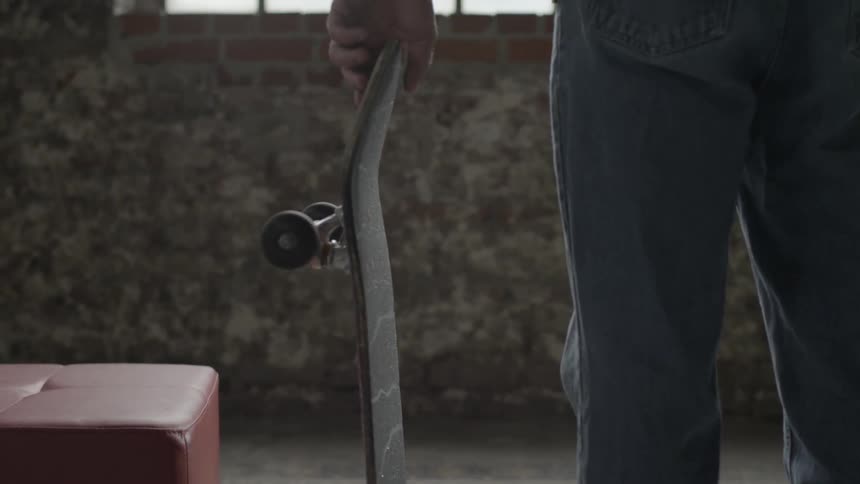 A man picks up a skateboard