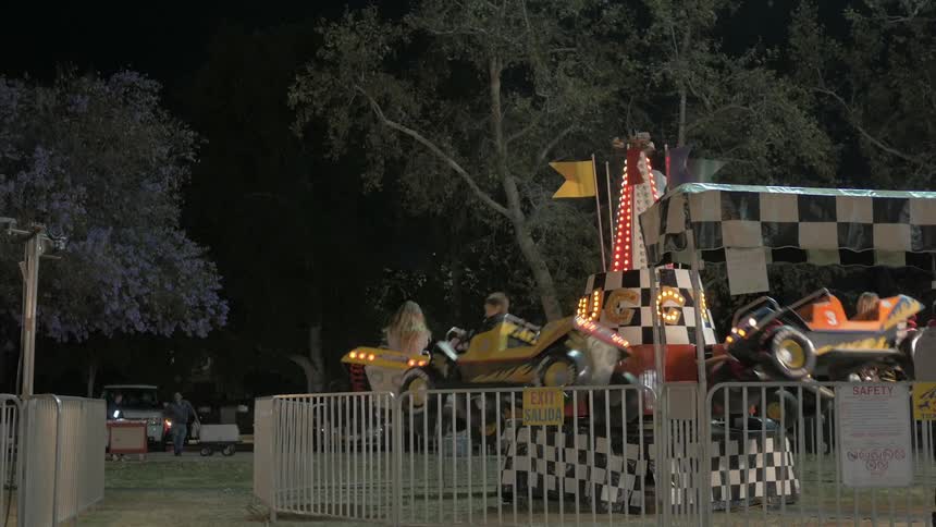 Kids riding on a fairground ride at night