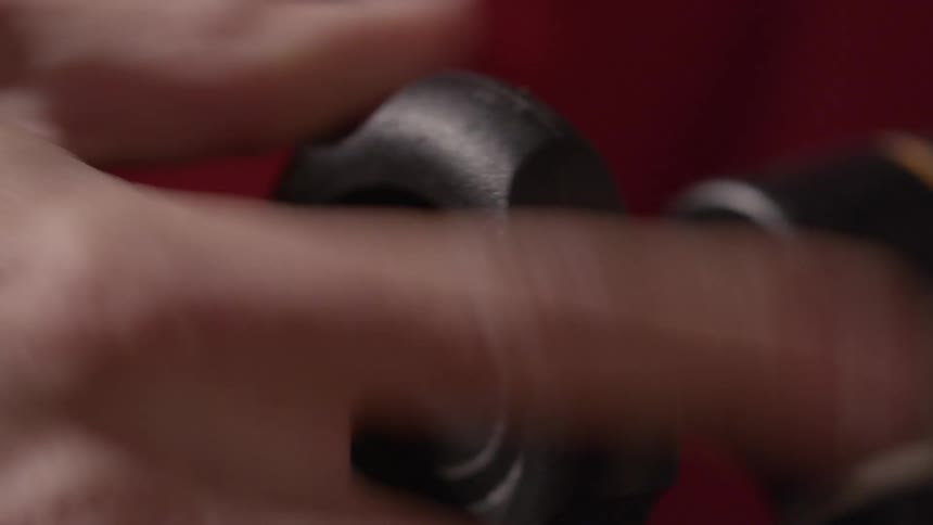 Closeup of a man's hand tightening a large knob