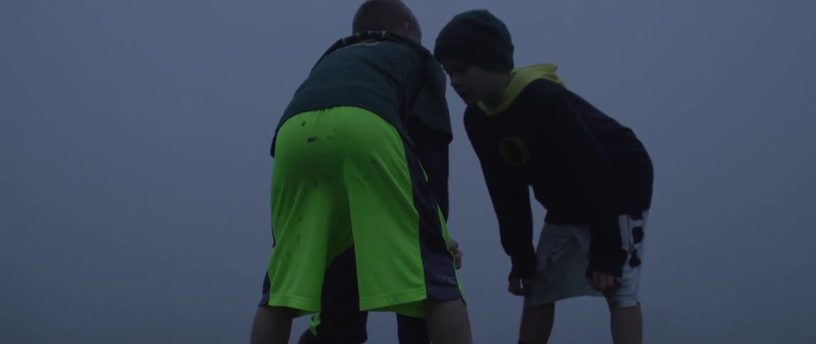 A group of boys huddle together on a field