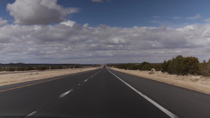 Driving down an empty road in the desert