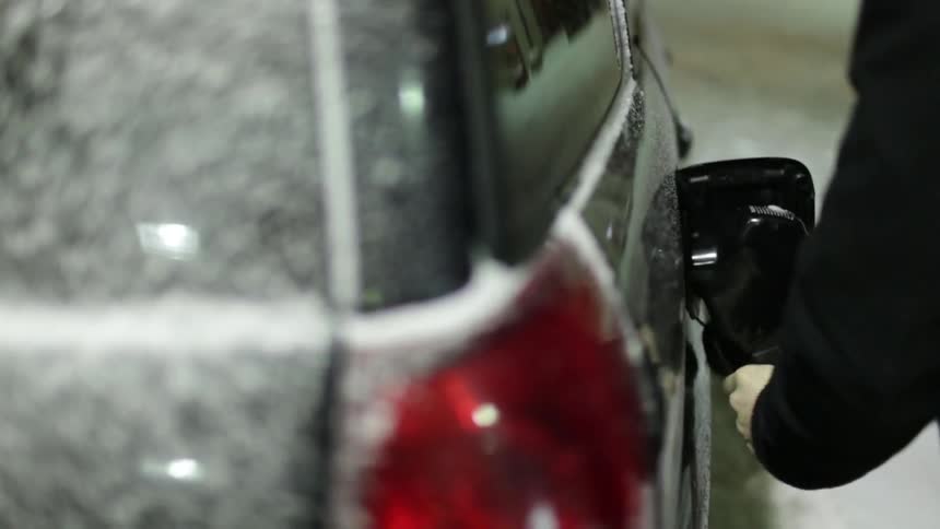 A man pumps gas into his vehicle