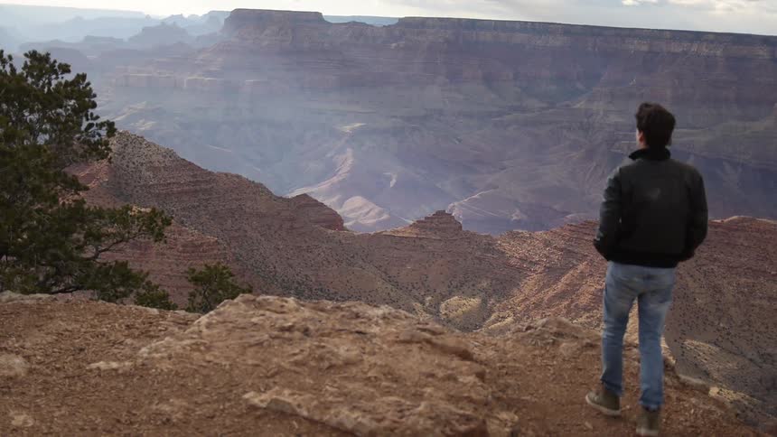 A man stops and observes a canyon