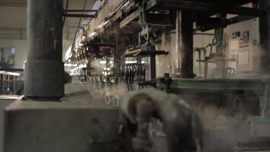Machinery working inside a factory with steam