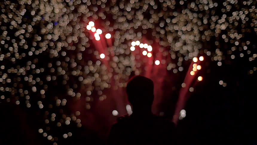 Man watching white and red fireworks in the night sky
