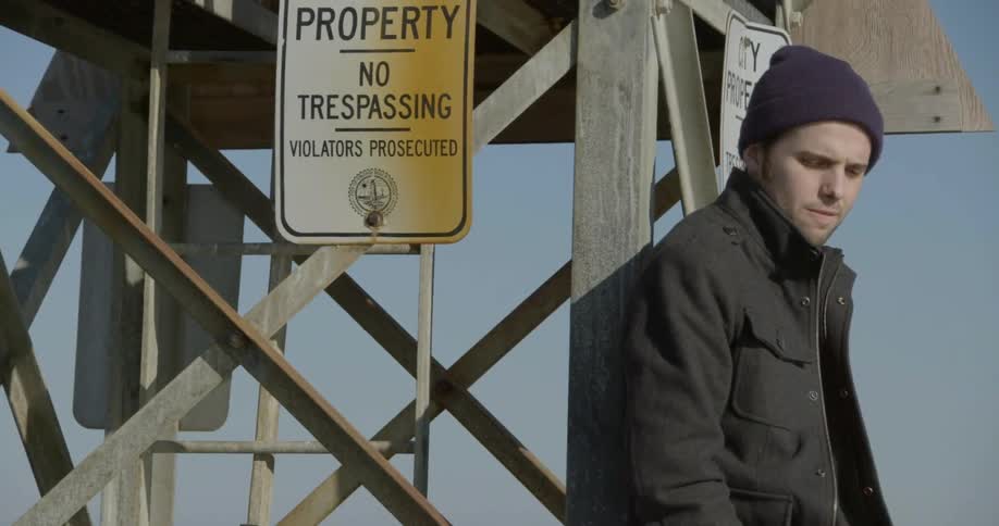 A man standing outside near a no trespassing sign
