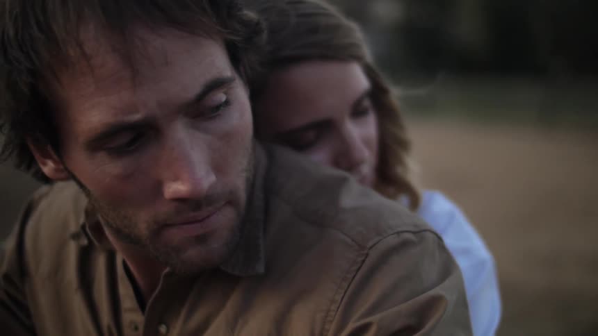 A woman leans on a mans back