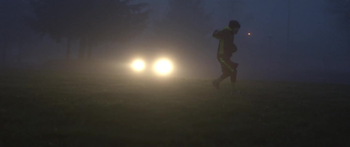 Child running with football at night