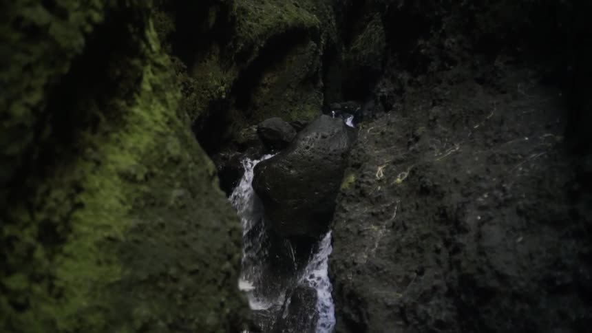 Water flowing down a rocky, mossy creek