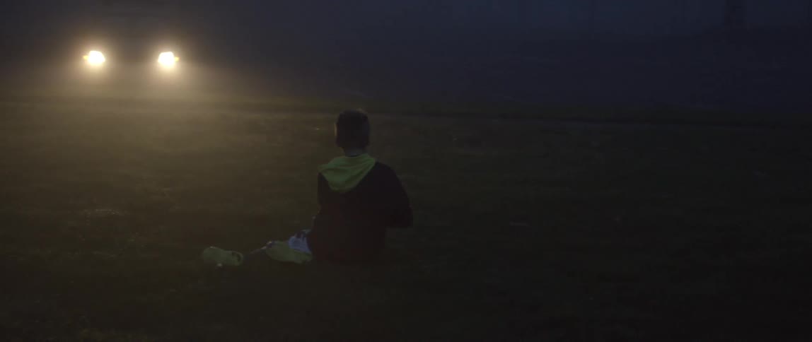 A boy catching a rugby ball in the park