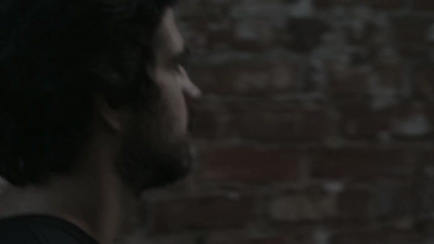 A man walks by a brick building