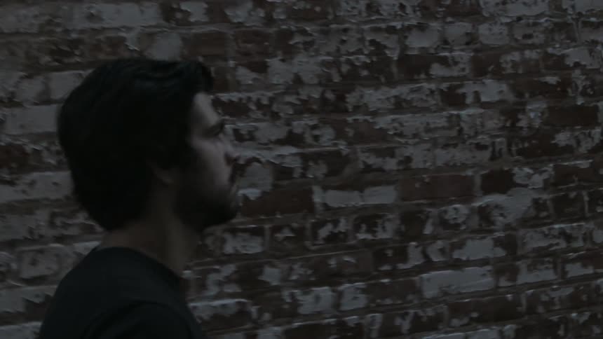 A man walks by a brick building