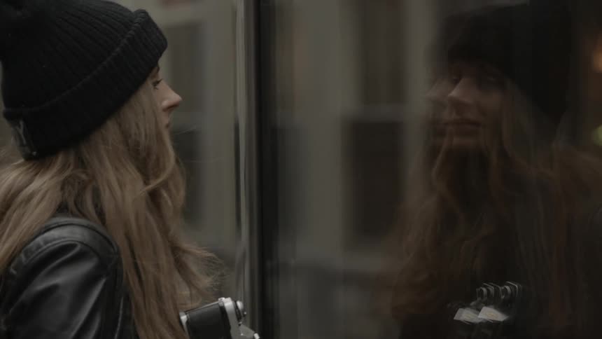 A woman looks through a window