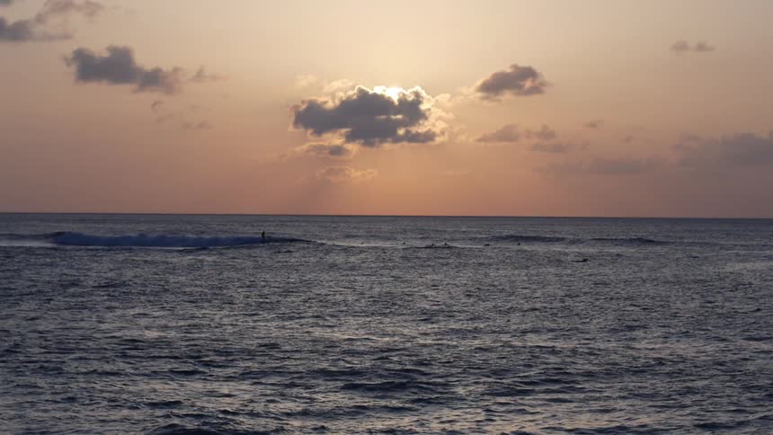 Surfers riding the waves out in the ocean on a cloudy day