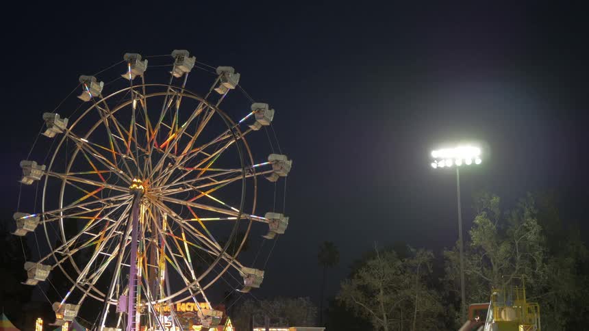 A ferris wheel lights up against a dark, night sky
