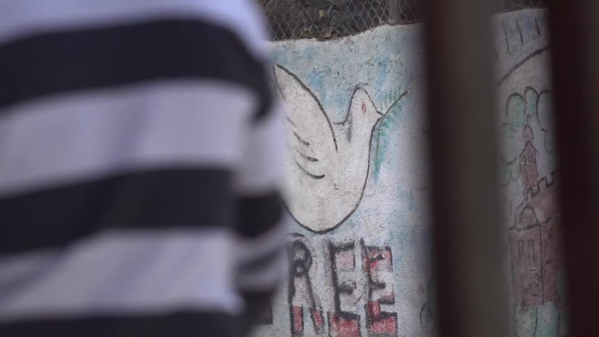 A man walks by a graffitied wall