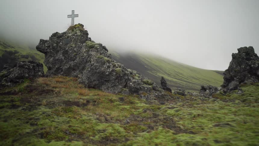 A cross sitting atop a rocky mountain