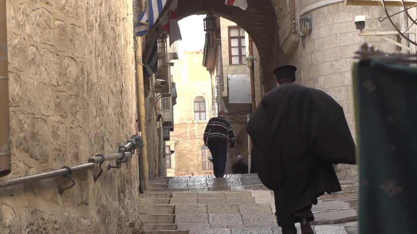 Two men walk between buildings
