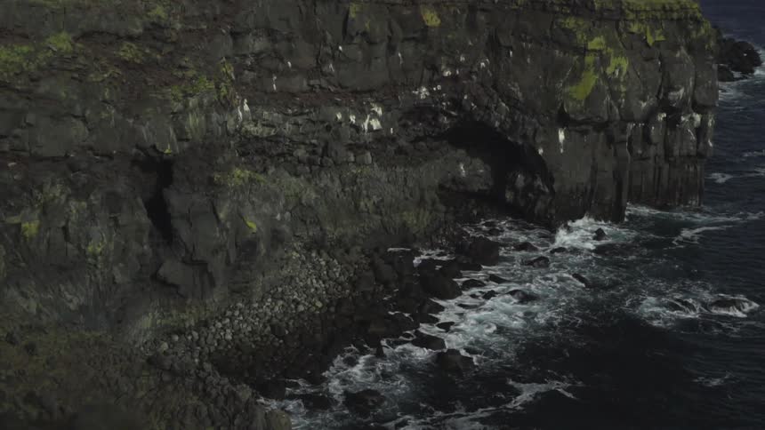 Waves crashing on a rocky cliff side