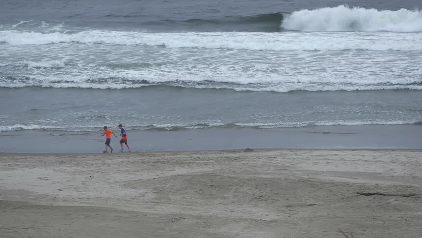 Two children kicking a ball on the beach