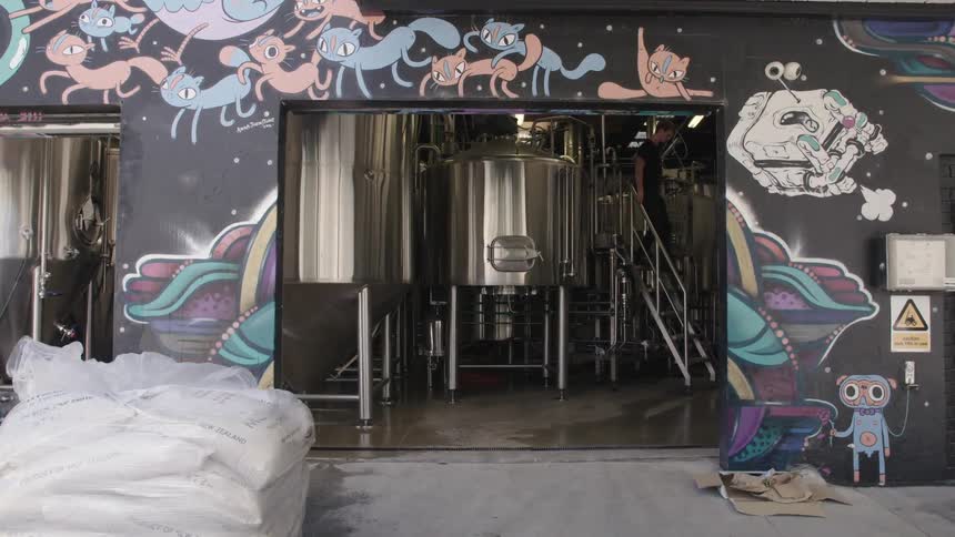 Man checking the fermenter containers in a building