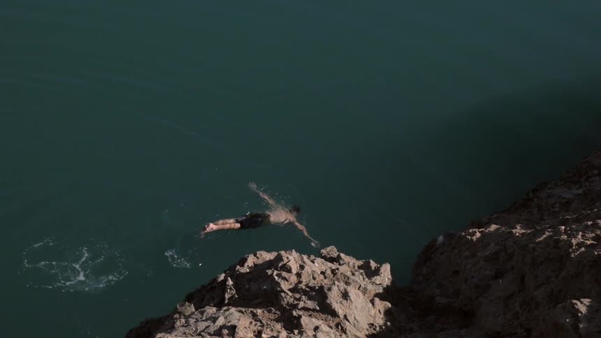 Man swims in clear lake water