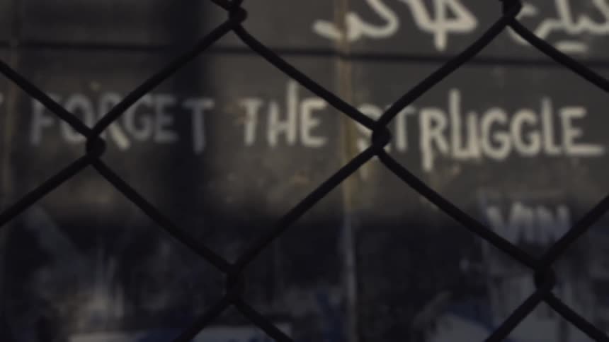 A message written on a wall behind a fence