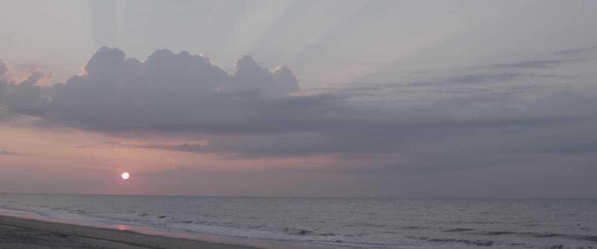 The sun is setting on the beach