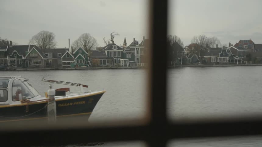 A scenery of river and boat through a window