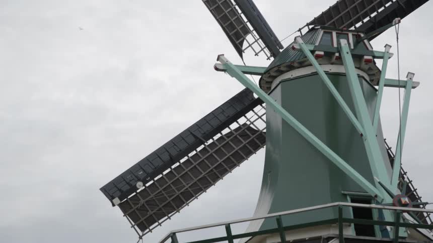 A large windmill moving slowly on a cloudy day