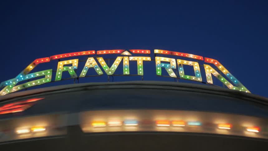 An amusement park ride lights up and spins