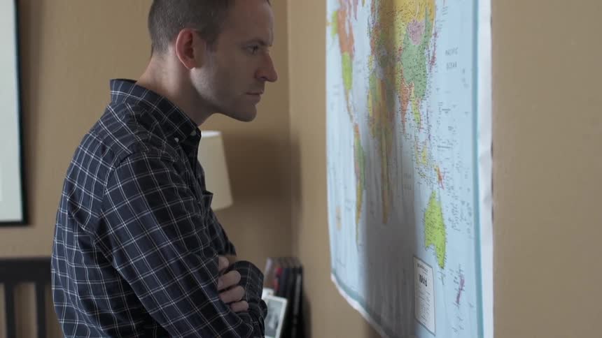 Man looking intensely at a map on a wall
