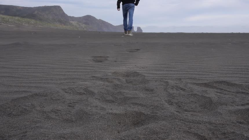 Person walking on the beach leaving footprints