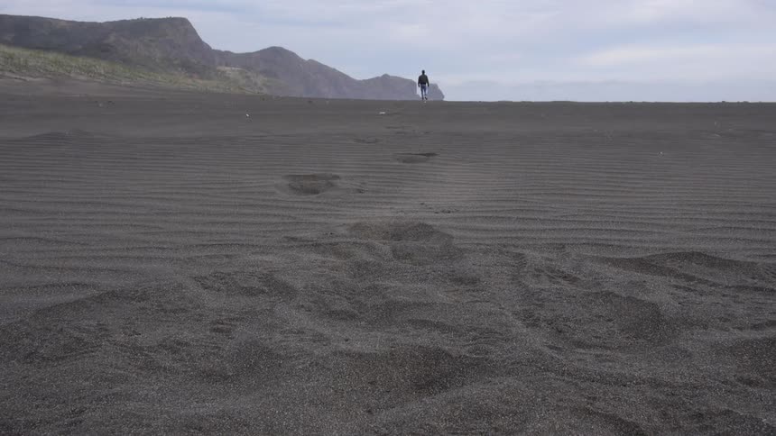 A person walking in sand