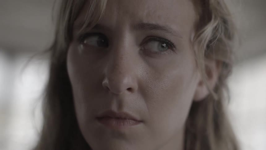 Closeup of a woman who warily watches the area around her