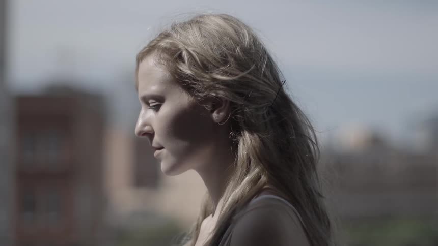 The sun shines on a woman in an urban area
