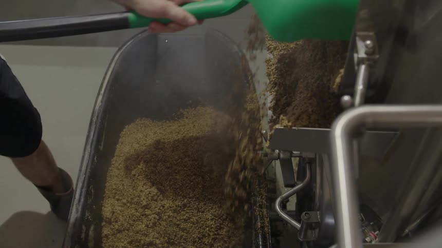 A person shoveling stuff out of a machine