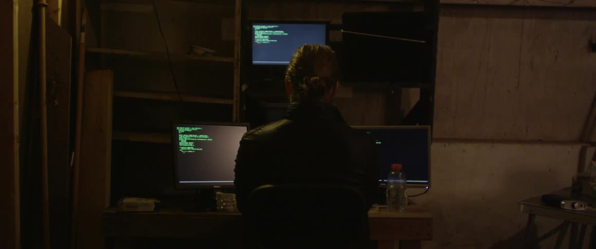A person working on a computer with multiple monitors
