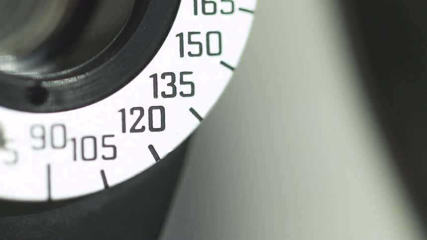 A silver dial with numbers turning away