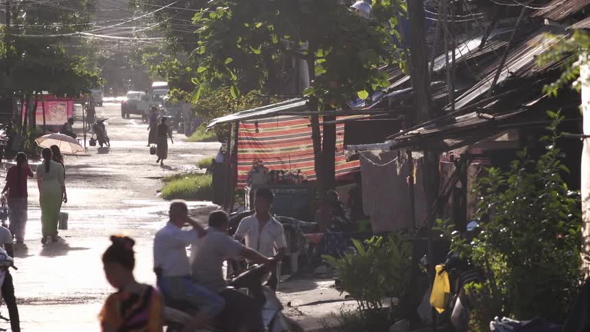 People walking down the street in a village on a sunny day