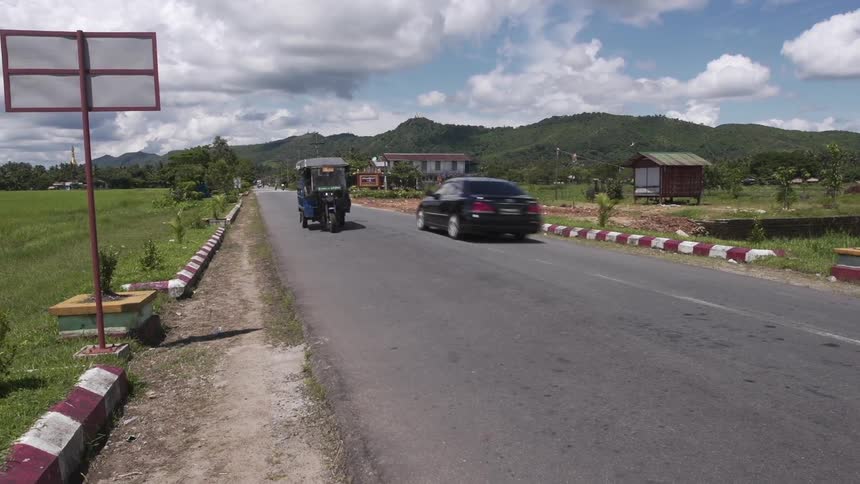 A bus-like vehicle travels along a road