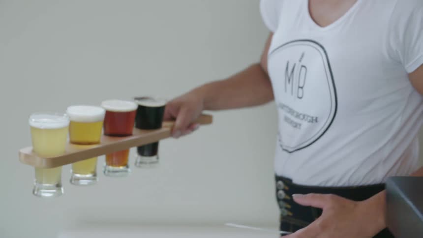 A waitress delivers a tray of beer to a table